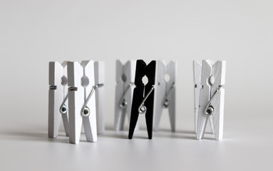 Many white tongs that surrounds one black tongs.