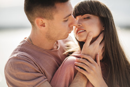 Loving young couple kissing and hugging in outdoors. Love and tenderness, dating, romance, family, anniversary concept.