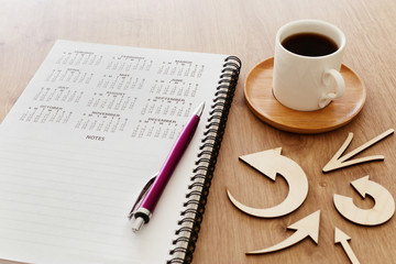 coffee cup and calendar over wooden table