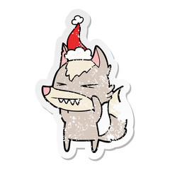 angry wolf distressed sticker cartoon of a wearing santa hat