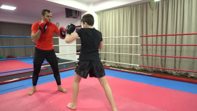Young kid hitting mitts with his coach