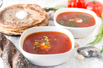 2 plates of borsch, pancakes, bread,