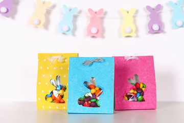 Diy Easter wrapping package sweets in a bag with a cut out bunny silhouette on a white background.