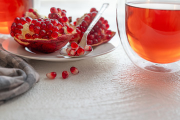 Pomegranate, pomegranate seeds, and pomegranate tea, white background, copy space