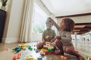 Kids playing with building blocks at home