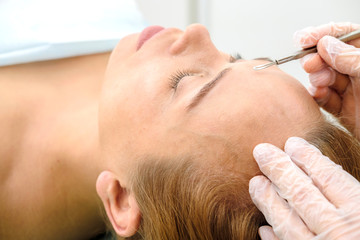 Procedure for cleaning skin with steel tool from blackheads and acne. Deep cleansing of the female face with blackhead remover in the beauty salon. Cosmetologist making receiving cleansing therapy