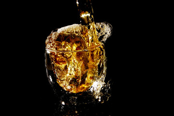 Glass of drink on black background