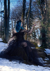 Fototapeta na wymiar Black queen. Blue hair woman portrait in forest.