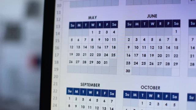 Person choosing date, looking through calendar on computer, wedding planning