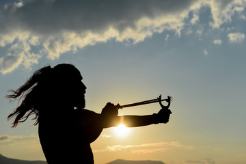 silhouette of man doing slingshot