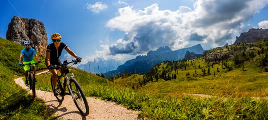  Cycling woman and man riding on bikes in Dolomites mountains landscape. Couple cycling MTB enduro trail track. Outdoor sport activity. © Gorilla