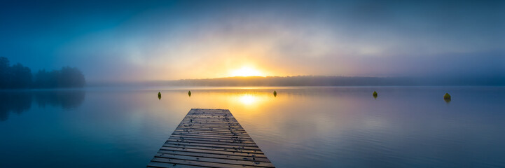Fototapeta na wymiar Sonnenaufgang am See mit Steg und Nebel - Panorama