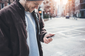 Man with mobile phone standing on the crossroad, city street situation