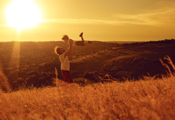 Father and child playing in nature at sunset. 