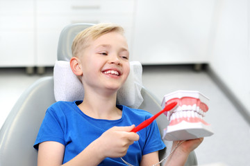 Stomatologia, radosne dziecko na fotelu dentystycznym - obrazy, fototapety, plakaty