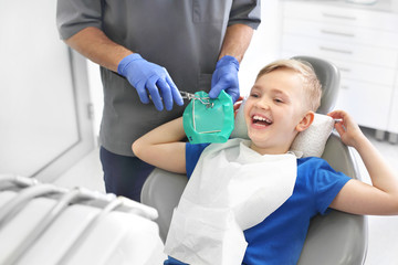 Dziecko u stomatologa.  Leczenie zęba, stomatolog czyści ubytek