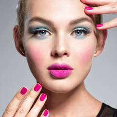 Beautiful woman  with blue makeup of eyes and pink nails.