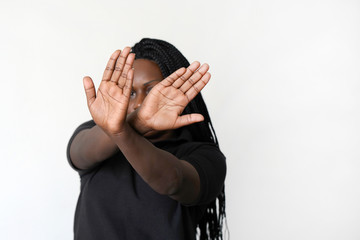 African woman hide her face at hand isolated on white background. Woman holding her hand stretched out toward the camera, covering her face, avoiding to be seen or stopping a problems