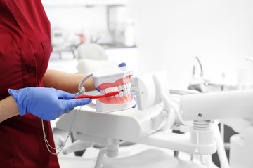 Prawidłowe szczotkowanie zębów. Stomatolog pokazuje jak myć zęby. - obrazy, fototapety, plakaty