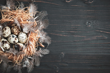 Quail eggs on old wooden background. Happy Easter. Top view. Free copy space. Selective focus.
