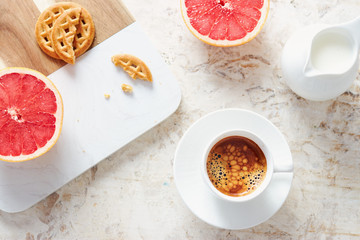 Breakfast table with fresh coffee, grapefruit and biscuits.