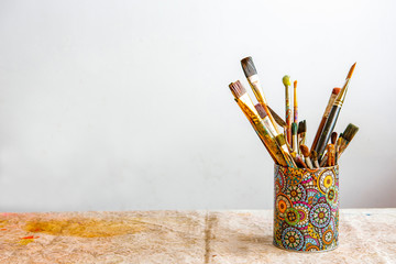 A Glass With Brushes For Painting Is On The Table
