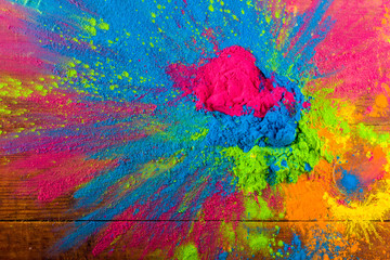 Abstract colorful Happy Holi background. Color vibrant powder on wood. Dust colored splash texture....