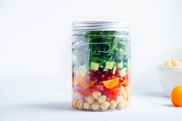 Healthy salad with chickpeas and arugula in a jar. Take away easy lunch concept