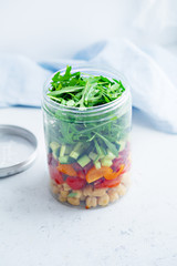 Healthy salad with chickpeas and arugula in a jar. Take away easy lunch concept