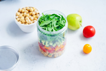 Healthy salad with chickpeas and arugula in a jar. Take away easy lunch concept