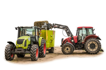 Fototapeta na wymiar The tractor with the loader loads a bale of silage in the distributor of mixed fodders for cows.Isolated photo. Necessary equipment for a dairy farm.