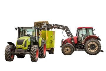 Obraz premium The tractor with the loader loads a bale of silage in the distributor of mixed fodders for cows.Isolated photo. Necessary equipment for a dairy farm.