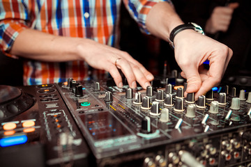 Dj mixes the track in nightclub at party