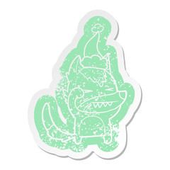 tired wolf cartoon distressed sticker of a wearing santa hat
