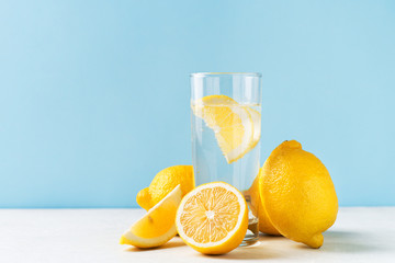 Detox lemon water with lemons fruit half and full on blue background