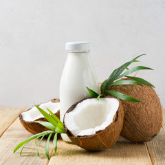 Fototapeta na wymiar Coconut milk in glass bottle with coconuts on white