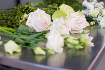 Beautiful white and pink flowers lie on the table for making up a beautiful wedding bouquet. Concept of master class of florist and wedding decor