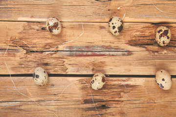 Quail eggs on wooden background. Happy easter.