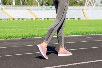 Naklejka na ściany i meble Ready to go. Close up photo of shoe of female athlete on the starting line. Girl on Stadium track, preparing for a run. Sports and healthy concept