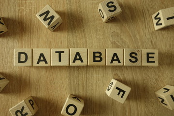 Database word from wooden blocks on desk