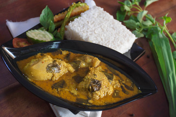 close up side view of chicken basil with rice on a wooden table