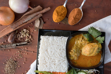 chicken curry with vegetable, herb and spices powder on a wooden table and white napkin