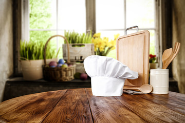 Desk of free space. Cook chef hat and kitchen desk. easter time and blurred background of window 