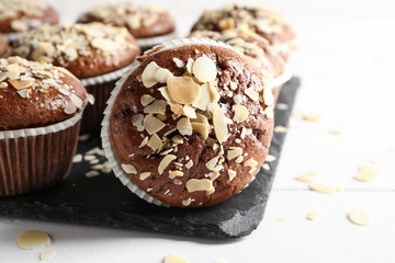 Tasty almond muffins on slate plate, closeup