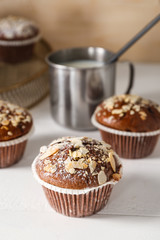 Tasty almond muffins on white table