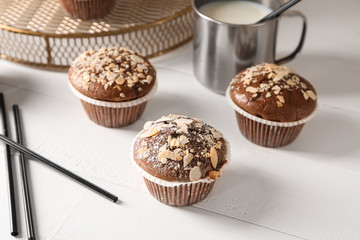 Tasty almond muffins on white table