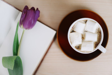 Beautiful tulip with book and cup of coffee on wooden background. Spring concept. top view. flatlay 