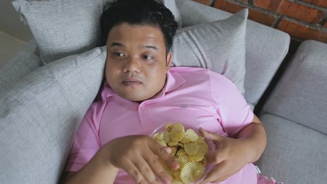 Picture of greedy person  eat snack and refusing fresh apple or healthy food