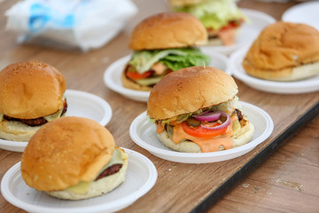 Table with delicious hamburgers on white plate