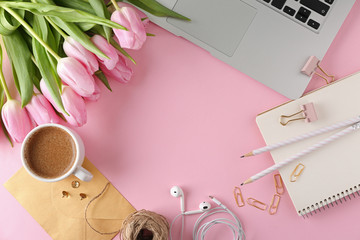 Stylish stationery with laptop, cup of coffee and tulips on color background